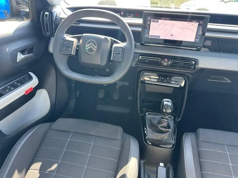 Vue intérieure avant de la Citroën C3 1.2 Turbo 2025, volant multifonction, écran tactile et levier de vitesse manuel.