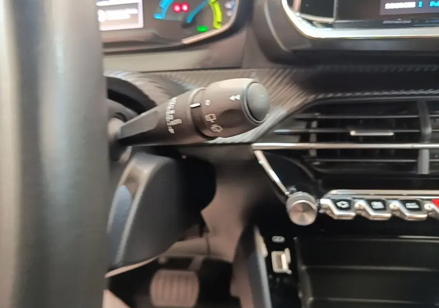 Détail du commodo d’essuie-glace et partie du tableau de bord noir du Peugeot E-2008 électrique 2023.