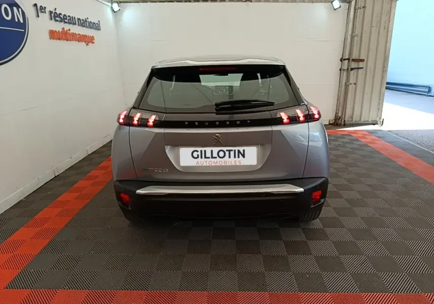 Vue arrière du Peugeot E-2008 électrique gris clair 2023 avec feux LED caractéristiques et toit noir contrasté.