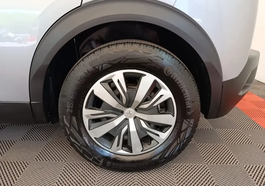 Gros plan sur la roue arrière droite gris clair du Peugeot E-2008 électrique avec jante alliage et pneu Continental.