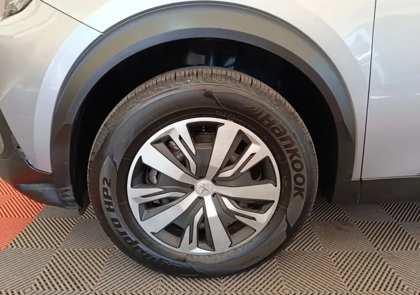 Gros plan sur la roue avant gauche d’un Peugeot E-2008 électrique gris clair avec jante spécifique et pneu Hankook.