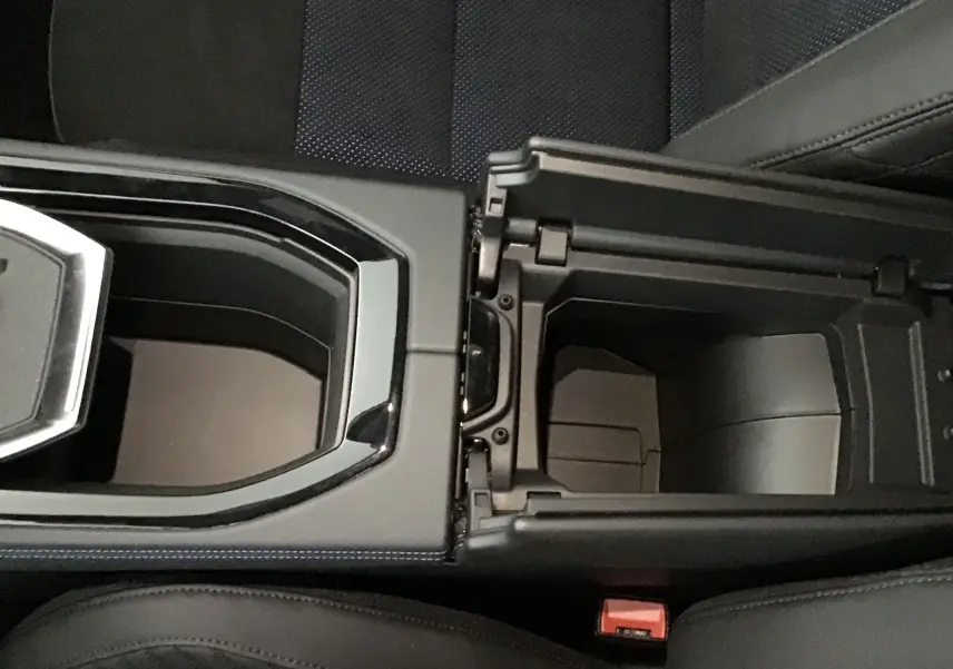 Vue rapprochée de la console centrale ouverte d'une Renault Rafale 2025 bleu sommet avec sellerie Alcantara noire et bleue.