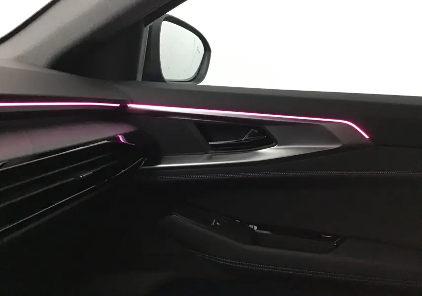 Intérieur côté gauche de la Renault Rafale bleu sommet 2025, éclairage d'ambiance rose sur la porte avec surpiqûres bleues.