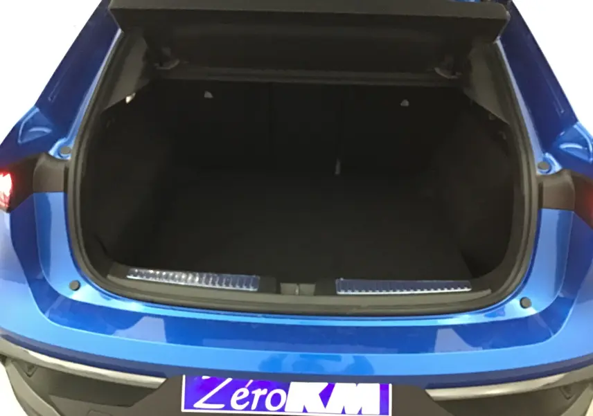 Coffre ouvert vu de l'arrière d'une Renault Rafale 2025 bleu sommet, soulignant l'espace de chargement vide.