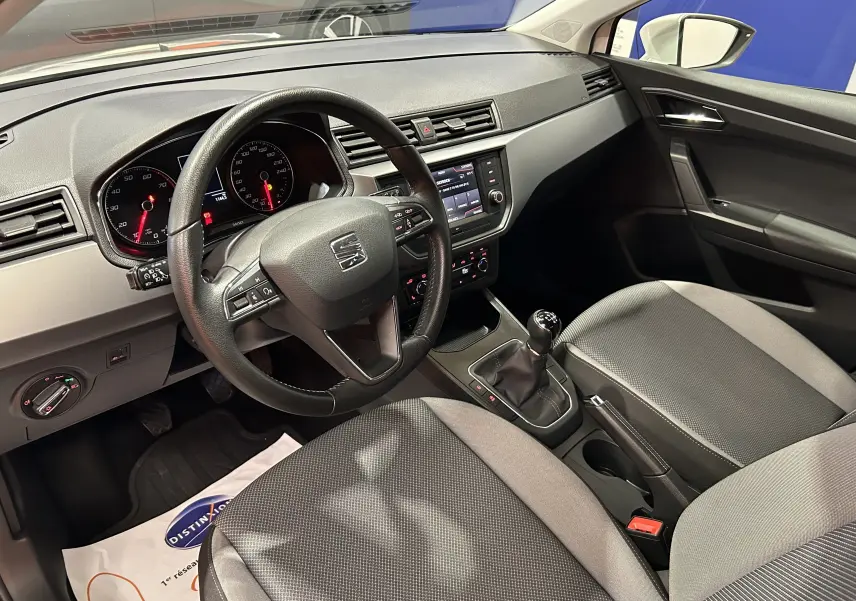 Intérieur de la SEAT Ibiza 2019 vu côté conducteur, volant multifonction et sièges tissu gris avec boîte manuelle.