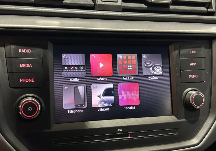Écran tactile central de la SEAT Ibiza 2019 blanc, vue rapprochée du système multimédia avec boutons latéraux.