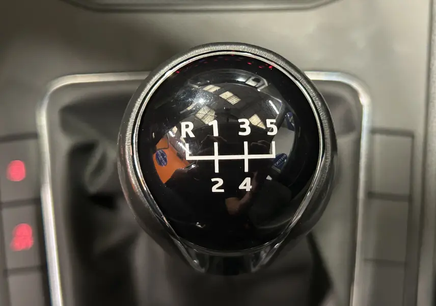 Gros plan sur le levier de vitesses manuel noir de la SEAT Ibiza blanche 2019, affichant les rapports 5 et marche arrière.