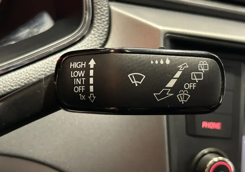 Gros plan sur la manette d'essuie-glace noire à l'intérieur d'une SEAT Ibiza blanche de 2019.