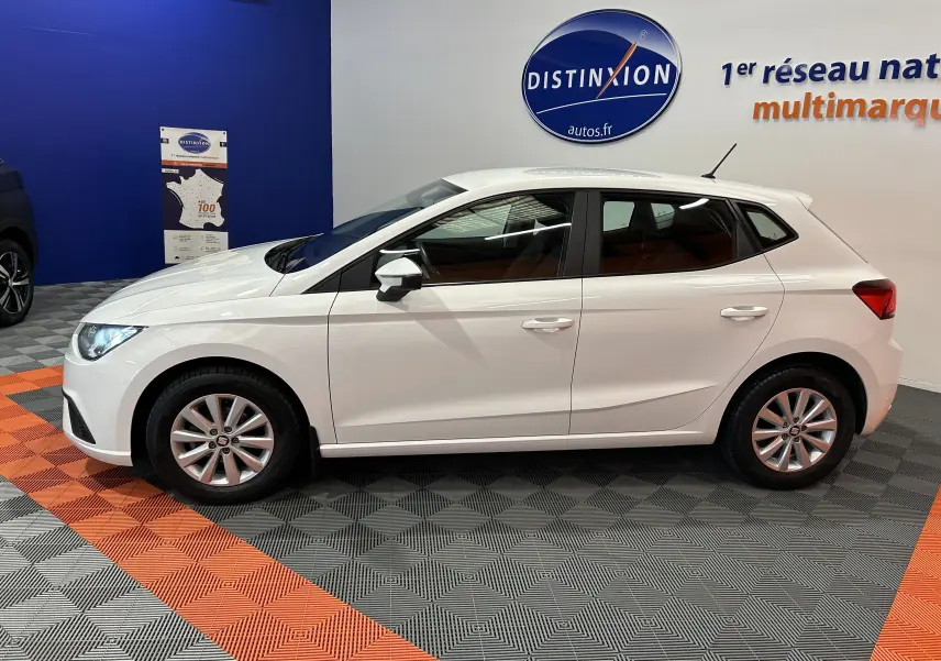 Profil côté gauche d'une SEAT Ibiza blanche 2019 en finition Style, exposée en showroom avec jantes alliage.