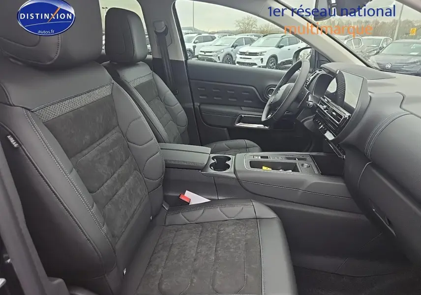 Intérieur du Citroën C5 Aircross 2025 vu côté passager, sièges noirs en cuir et alcantara avec console centrale moderne.