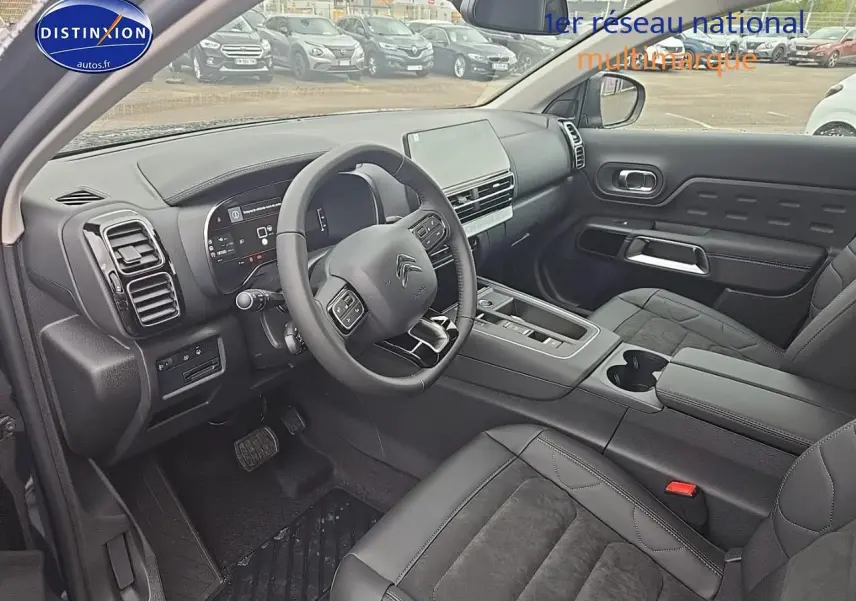 Intérieur du Citroën C5 Aircross 2025 vu côté conducteur, avec tableau de bord digital et sièges noirs cuir et alcantara.
