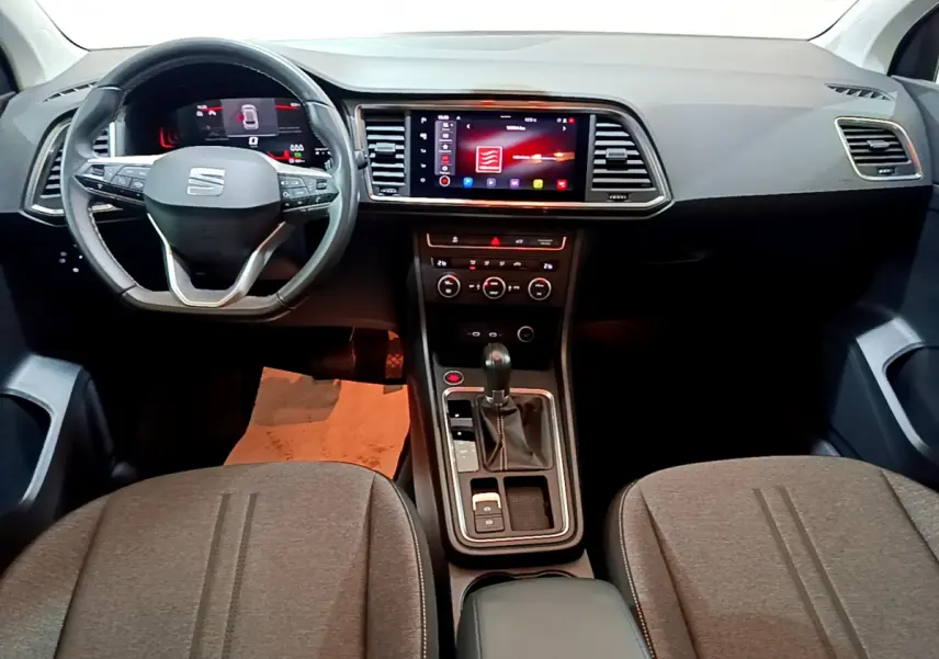 Vue intérieure avant du tableau de bord et console centrale du SEAT Ateca noir avec écran tactile et volant multifonctions.