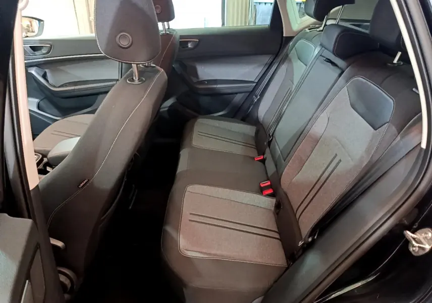 Vue intérieure côté droit sur la banquette arrière grise et noire du SEAT Ateca noir 2022 avec portes ouvertes.