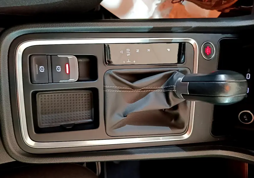 Vue rapprochée de la console centrale noire du SEAT Ateca 2022 avec levier de vitesses automatique et bouton démarrage rouge.