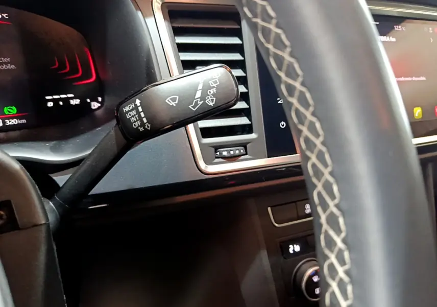 Gros plan sur la manette d’essuie-glace à gauche du volant cuir du tableau de bord noir du SEAT Ateca 2022.