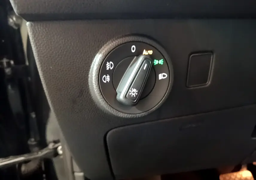 Gros plan sur le bouton de commande des phares du tableau de bord d'un SEAT Ateca noir 2022.