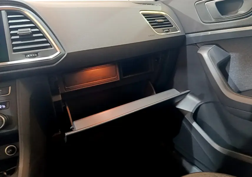 Intérieur SEAT Ateca 2022 vue côté passager, boîte à gants ouverte, tableau de bord noir et garnitures grises.