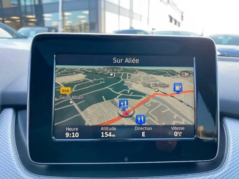 Écran de navigation GPS intérieur de Mercedes Classe B 180 d 2016, affichant une carte avec itinéraire en rouge.