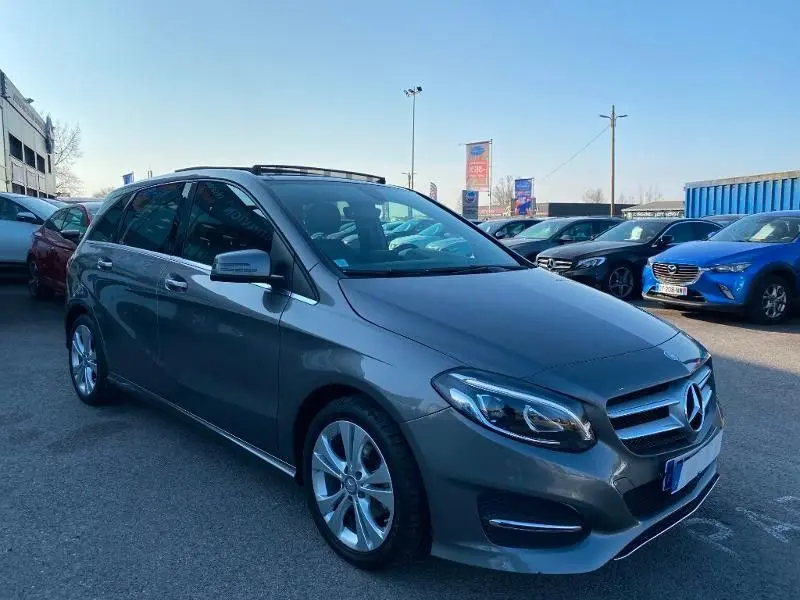 Mercedes Classe B 180 d gris foncé métallisé vue 3/4 avant droit, avec calandre et jantes alliage visibles.