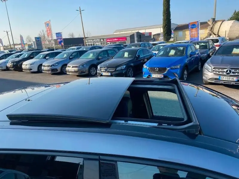 Toit ouvrant partiellement ouvert sur une Mercedes Classe B 180 d gris foncé métal, vue en plongée extérieure.