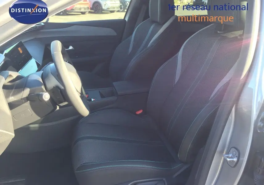 Vue intérieure côté conducteur de la Peugeot 308 gris Artense, montrant les sièges et le volant.