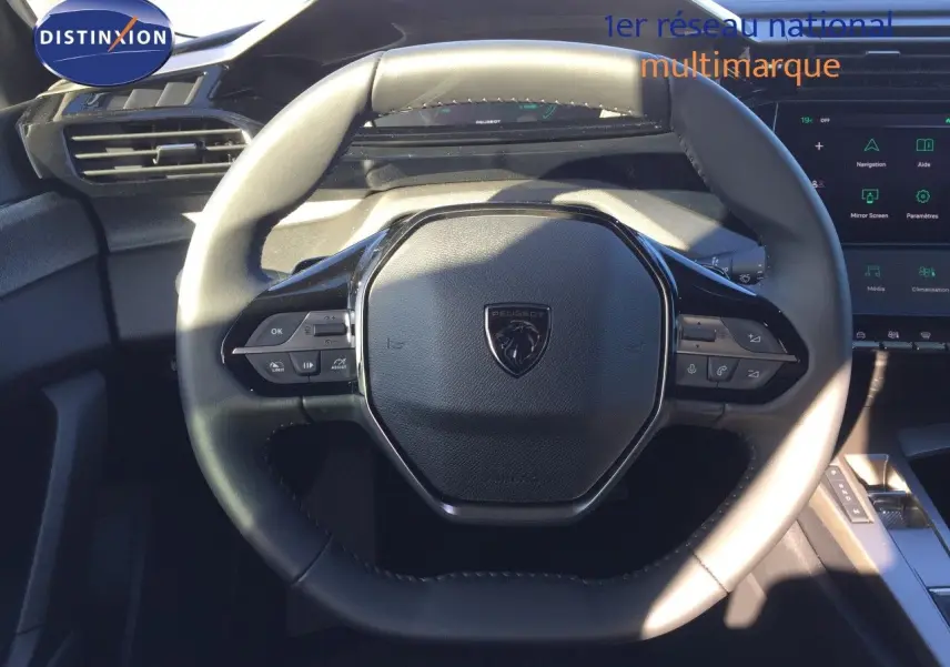 Vue rapprochée du volant cuir noir de la Peugeot 308 1.2 Hybrid 2025 avec commandes intégrées et tableau de bord digital.