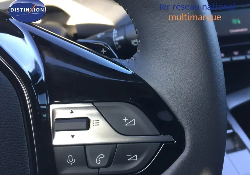 Détail du volant avec commandes intégrées sur Peugeot 308 gris Artense, intérieur moderne et finition soignée.
