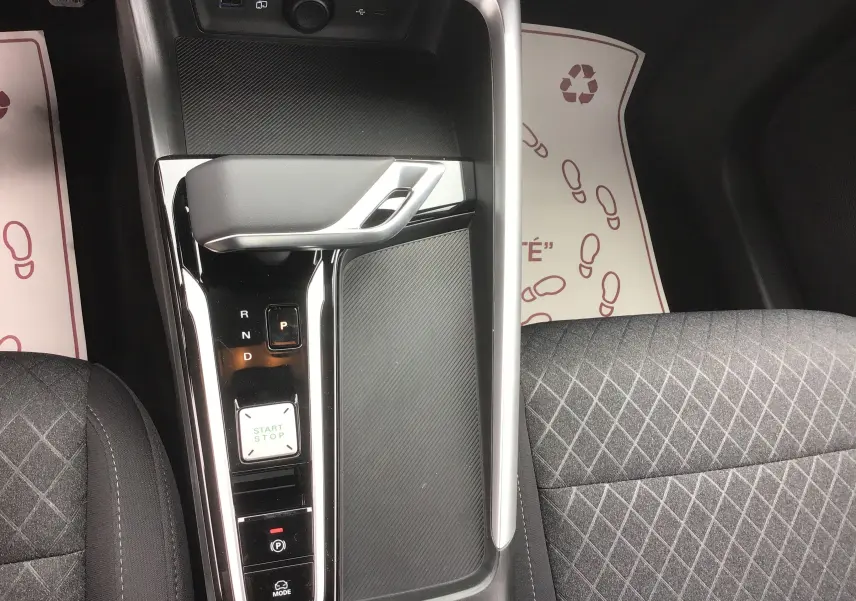 Vue plongeante sur la console centrale du MG ZS Cosmic Silver, montrant levier de boîte auto et sièges tissu noir.