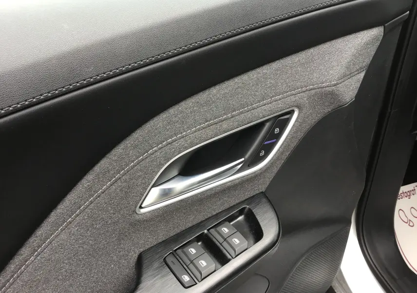 Détail de la porte côté conducteur du MG ZS Cosmic Silver 2026, avec garniture tissu gris et commandes électriques.