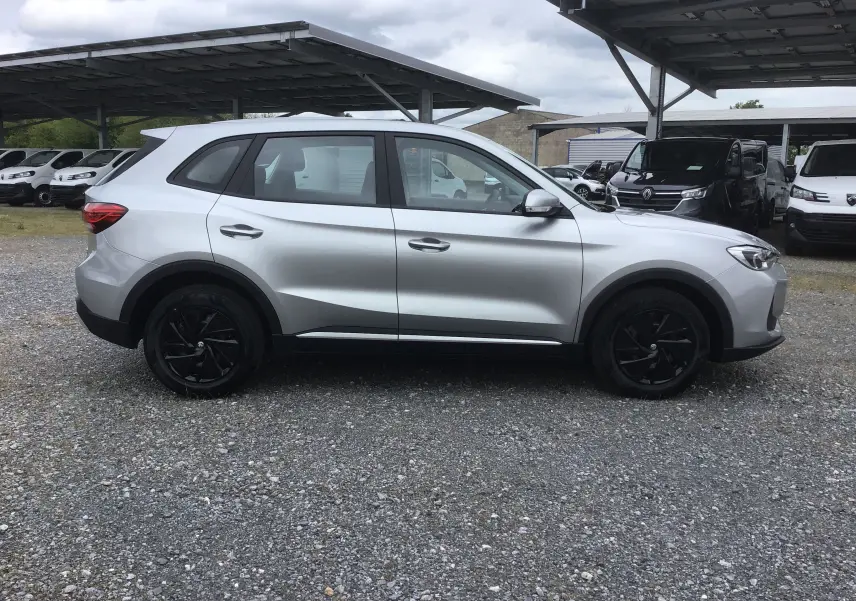 Vue de profil côté gauche du MG ZS Cosmic Silver avec jantes noires et détails noirs sur les bas de caisse.