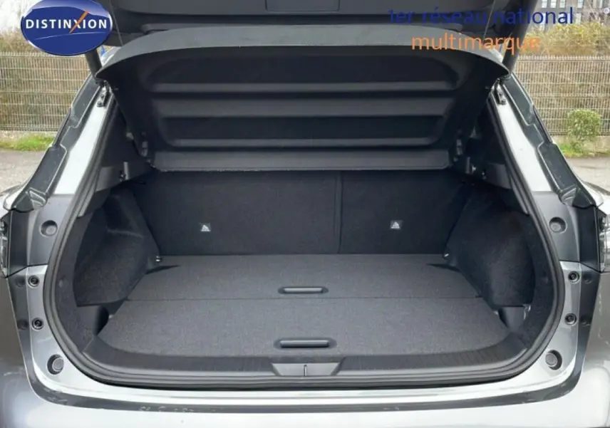 Coffre ouvert en vue arrière d’un Nissan Qashqai gris 2025, montrant un espace de chargement spacieux et propre.