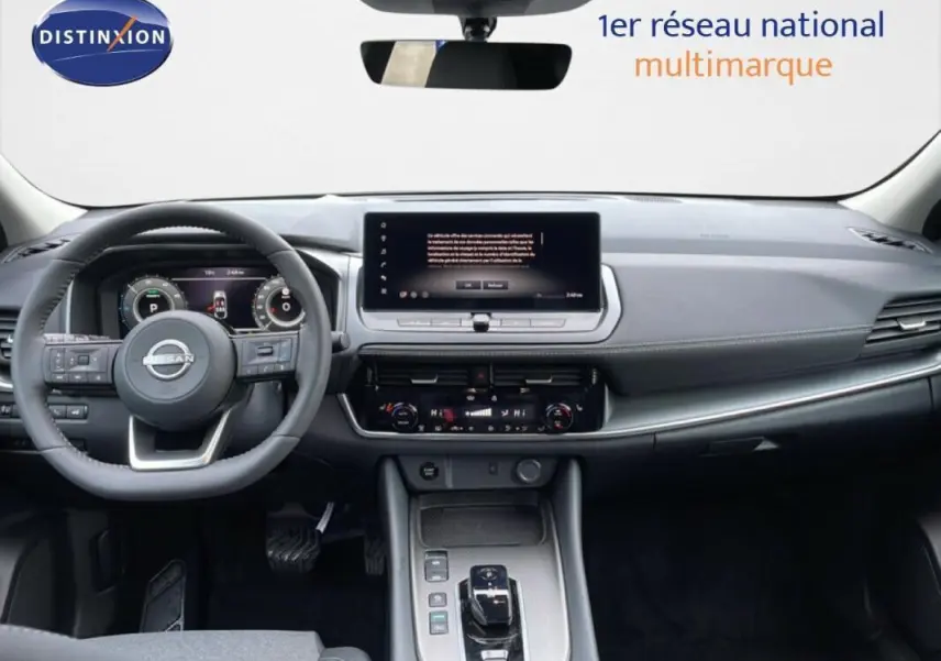 Intérieur du Nissan Qashqai 2025 gris, vue frontale du tableau de bord avec écran tactile et volant multifonctions cuir.