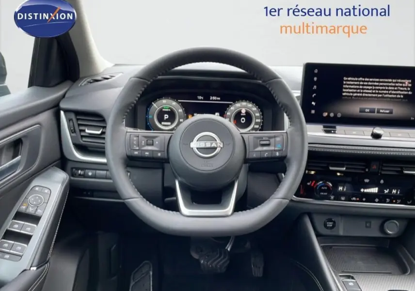 Vue intérieure frontale du volant cuir et du tableau de bord numérique du Nissan Qashqai gris 2025 avec écran tactile.