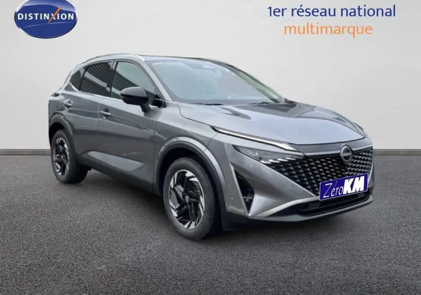 Vue 3/4 avant droit du Nissan Qashqai gris 2025 avec calandre noire et jantes modernes.