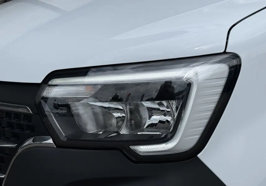 Gros plan sur le phare avant droit du Renault Master blanc 2024, mettant en valeur son design moderne et ses LED.