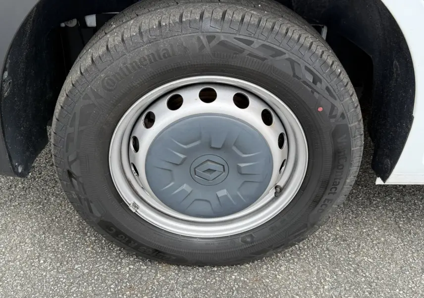 Gros plan sur la roue avant droite du Renault Master blanc avec jante acier et logo Renault au centre.