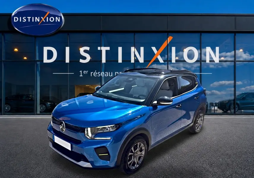 SUV Citroën C3 bleu en 3/4 avant droit, avec toit noir et jantes alliage, devant une vitrine Distinxion.