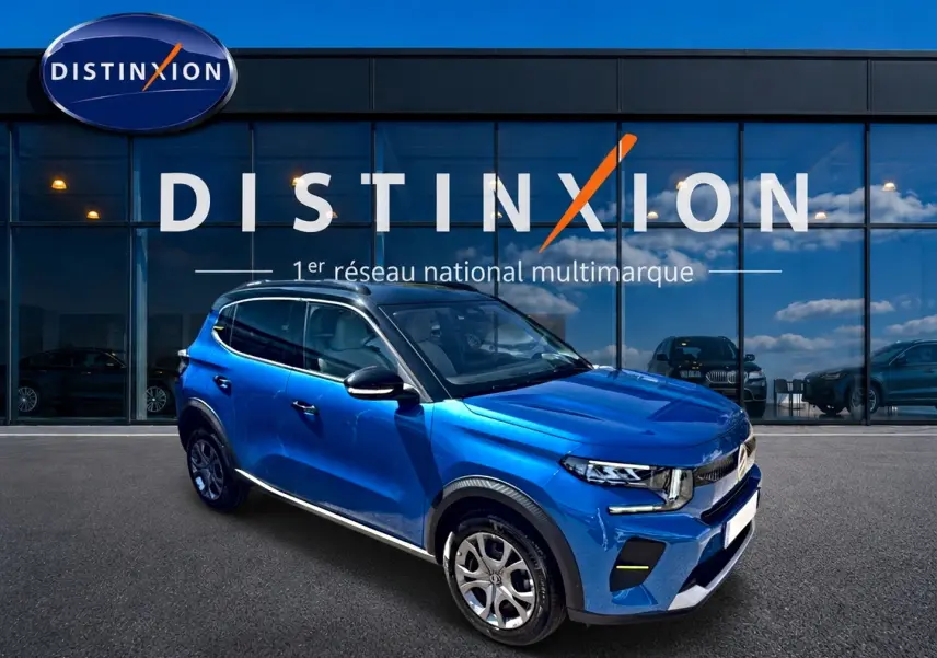 Citroën C3 1.2 turbo bleu en 3/4 avant droit, avec toit noir et jantes alu devant showroom Distinxion.