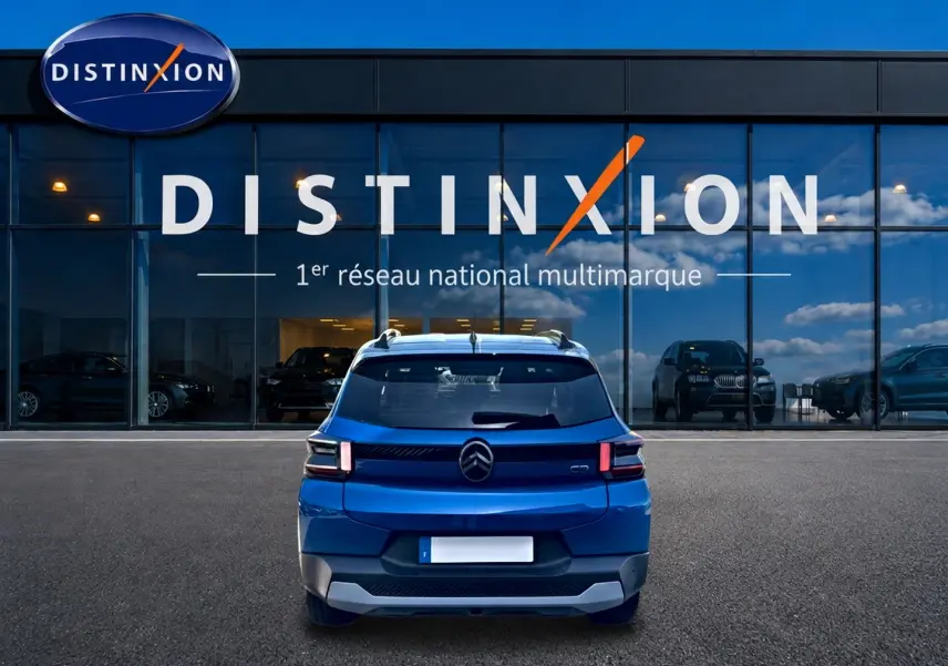 Vue arrière d'une Citroën C3 bleu 2025 avec feux arrière LED, stationnée devant une vitrine Distinxion.
