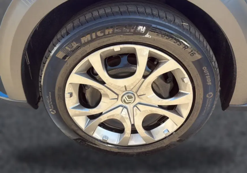 Gros plan sur la jante alu argentée et le pneu Michelin d'une Citroën C3 bleu, côté avant droit.
