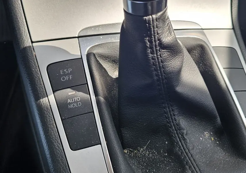 Gros plan sur la console centrale de la Volkswagen Passat bleue 2009, montrant le levier de vitesse manuel et les boutons ESP OFF et AUTO HOLD.