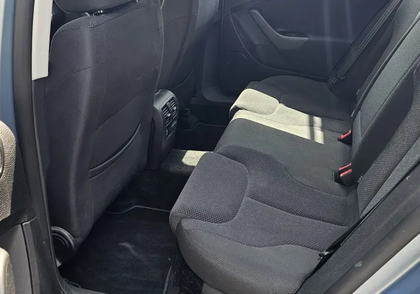 Vue intérieure côté droit sur les sièges arrière noirs d'une Volkswagen Passat 1.4 TSI bleu de 2009.