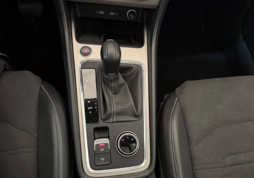 Vue rapprochée de la console centrale du SEAT Ateca gris clair 2023, avec levier de vitesses automatique et commandes de mode de conduite.