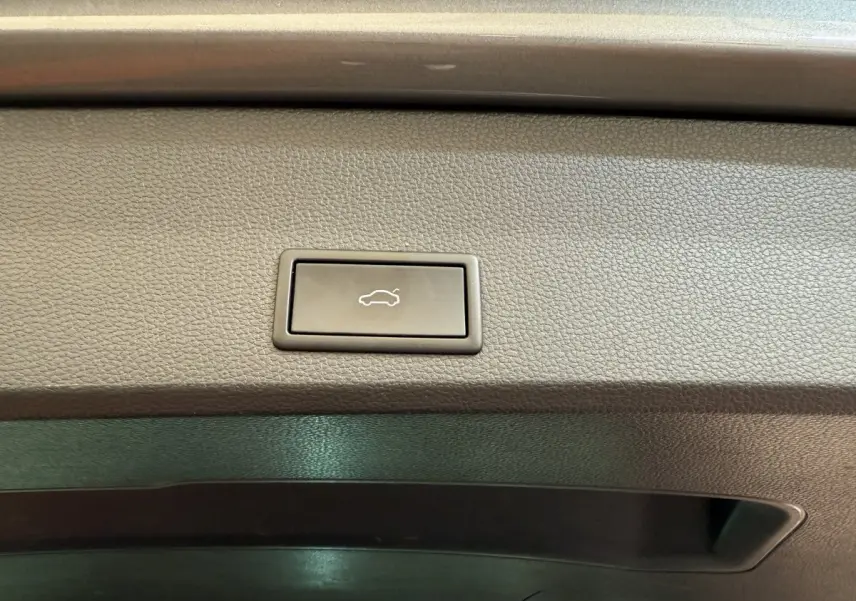 Bouton d'ouverture électrique du coffre sur la garniture intérieure grise du SEAT Ateca 2023.