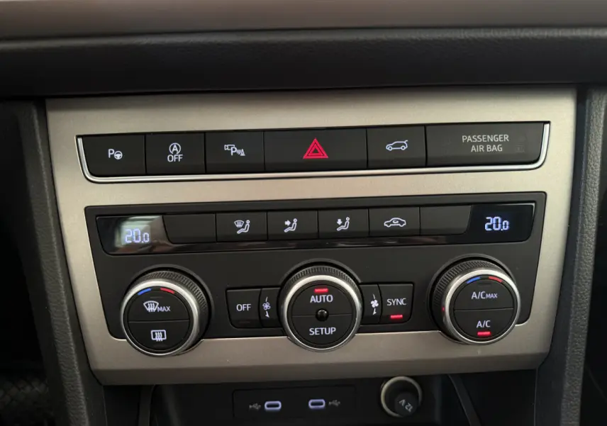 Panneau de commande central de la climatisation du SEAT Ateca gris clair 2023 avec affichage digital et boutons rotatifs.