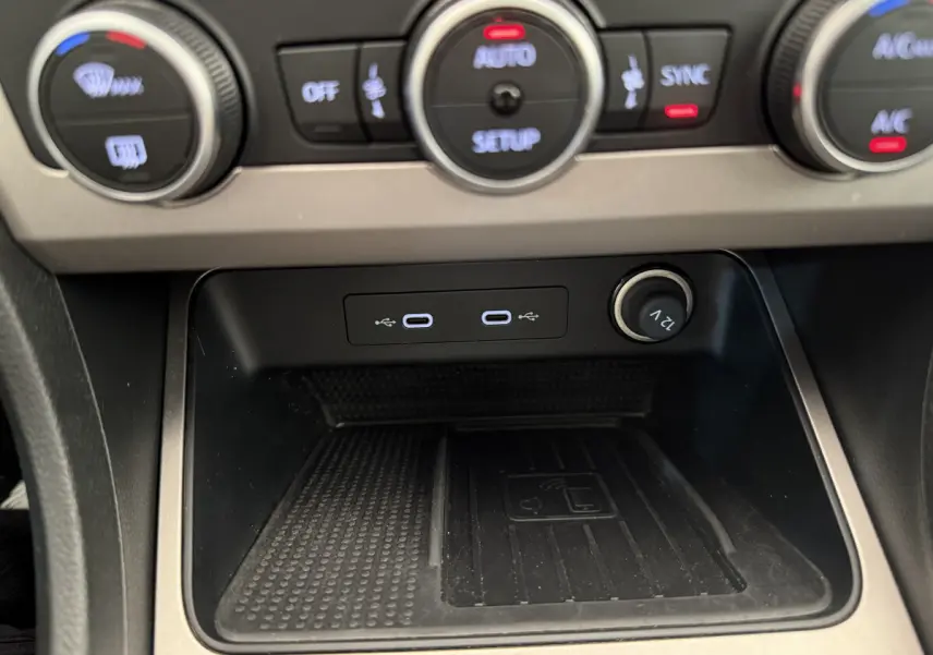 Gros plan sur la console centrale du SEAT Ateca gris clair 2023, montrant les ports USB-C et prise 12V avec commandes climatisation.