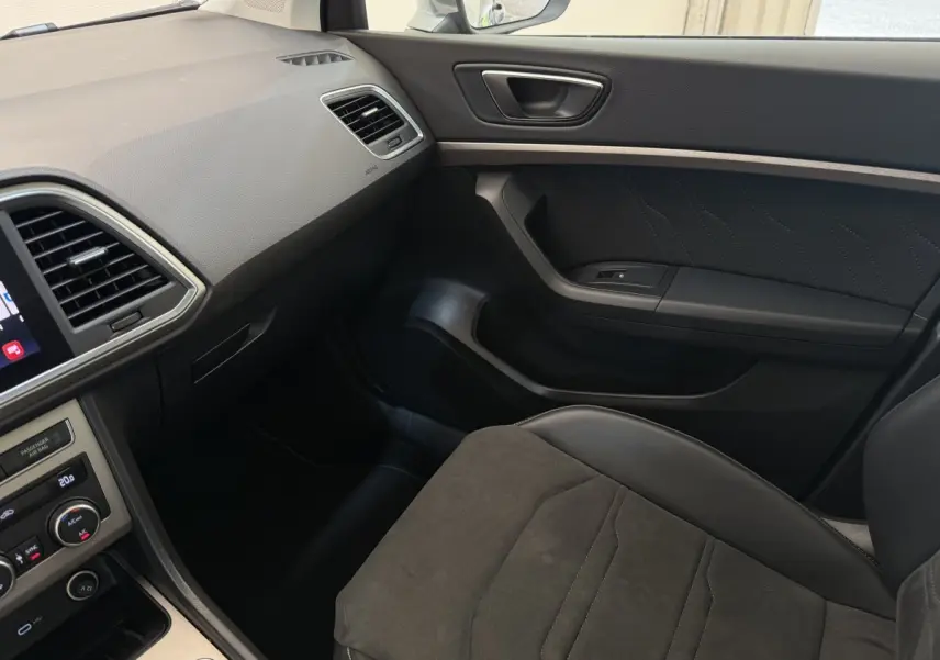 Vue intérieure côté passager du tableau de bord et siège noir du SEAT Ateca 2023 avec finitions modernes et écran tactile.