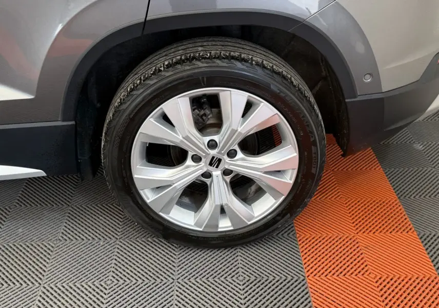 Gros plan sur la roue avant droite gris clair du SEAT Ateca 2023 avec jante alliage et logo central visible.