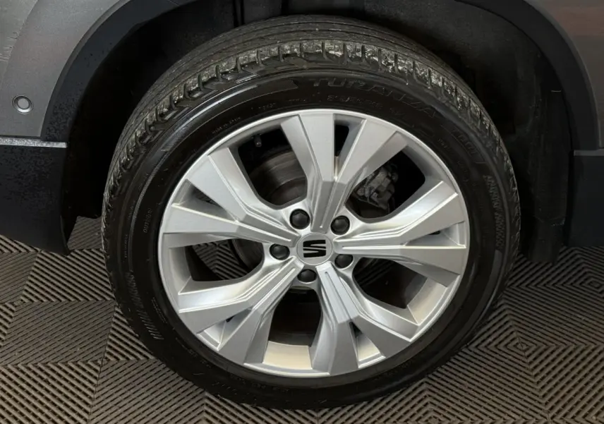 Gros plan sur la roue avant droite du SEAT Ateca gris clair 2023 avec jante alliage à design moderne.