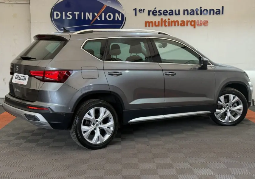 SEAT Ateca gris clair vue de profil côté gauche, SUV compact avec jantes alliage et toit avec barres chromées.